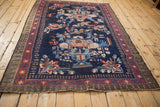 Navy blue field with madder red starburst border and worn olive-toned selvedge on an Afshar rug.