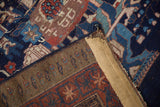 Vintage Afshar rug reverse with partially frayed binding and geometric patterns in blue, red, brown.