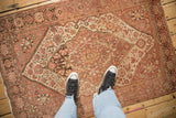 A personal perspective showing the even wear and dusty rose tones of an antique Farahan Sarouk rug.
