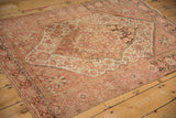Angled view of an antique Farahan Sarouk rug highlighting its medallion and spandrel design.