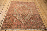 Full angled view of the antique distressed Farahan Sarouk rug, showcasing its time-softened dusty rose palette.
