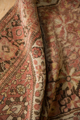 Hand-knotted pile of a Farahan Sarouk rug showing mostly even wear and time-softened dusty rose tones.