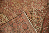 A folded corner reveals the hand-knotted construction and distressed pile of an antique Sarouk.