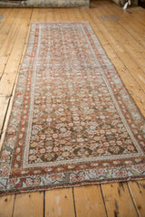 Distressed terracotta red vine border, beige boteh elements, and muted Herati field.