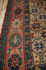 Detail of a Kazak rug's borders, showing top-view floral motifs and geometric pawn designs.