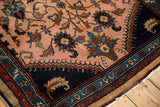 Detailed view of a vintage Mehreban rug's corner with floral vines and low hand-knotted pile.