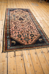 Vintage Mehreban runner seen from an angle, highlighting its elaborate vine pattern and navy accents.