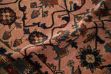 Hand-knotted pile detail of a vintage Persian rug with navy vines on a dusty magenta field.