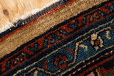 Detail of the Mehreban rug's intact side cord, camel outer border, and narrow inner bands.