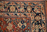 Corner view of a vintage Sarouk's arabesque and lotus flower borders in navy blue, brick red, and sand.