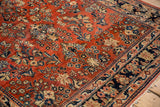Corner detail of a vintage Sarouk showing floral sprays, low pile, and visible knot heads.