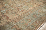 Low, distressed pile of a Ghiordes carpet with sandalwood and slate blue florals.