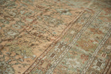 Worn pile of a vintage Ghiordes carpet showing floral motifs in sandalwood and dusty copper.