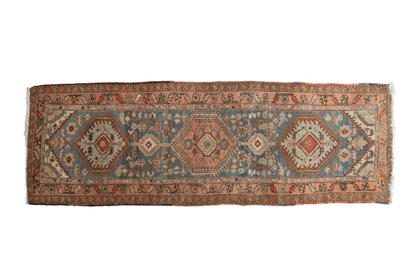 Vintage Heriz runner with triple medallions, floral field, and serrated border in blue, rose, and red.