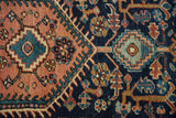 Vintage Heriz rug close-up: stepped medallions and blossoms in dusty rose, navy, and teal.