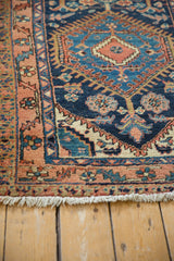 Off-white fringe and geometric dusty rose, navy border on a vintage Heriz runner.