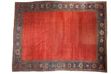 Antique Sultanabad carpet with striated cochineal red field and deep sapphire blue floral border.