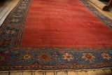 Antique Sultanabad rug's deep sapphire blue border with colorful palmettes and floral motifs.