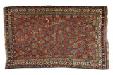 Antique Qashqai rug: chestnut field, allover germinating shrub design, scattered birds, vine borders.