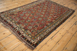 Antique Qashqai rug: meandering vine borders, germinating shrub motif, chestnut, and denim blue.