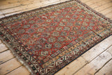 Antique Qashqai rug side detail: chestnut field, germinating shrub, scattered birds, vine border.