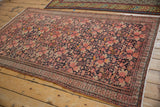 Antique Malayer rug: dusty blush floral pattern on navy ground, intricate germinating blossom border.