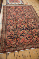 Antique Malayer rug: dusty blush floral bouquets on navy, intricate germinating blossom border.
