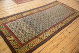 Angled view of an antique Caucasian runner's geometric lattice field and vibrant, intricate main border.