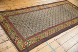High-angle view of the antique Caucasian rug runner, displaying its full geometric lattice and colorful border.