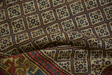 Close detail of a Caucasian rug's geometric lattice panels and time-softened hand-knotted pile.