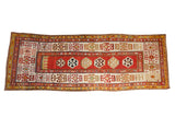Antique Kazak runner with a red central medallion column and wide, geometric ivory borders.