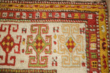 Detail of a Kazak rug corner showing the geometric rams horn and serpent motif borders.