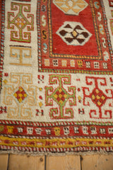 Detail of an antique Kazak runner's wide border with stylized geometric guls in green and madder red.