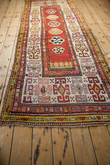 Angled view down the length of an antique Kazak runner with its central column of medallions.