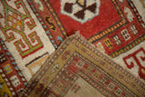 A folded corner on an antique Kazak rug contrasts the textured wool pile with the flat-woven foundation.