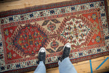 Vintage Persian Serab runner showing its scale, with twin geometric medallions and a reciprocating pawn border.