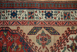 Reciprocating pawn and floral blossom motifs in the intricate borders of the vintage Serab rug.