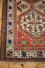 Detailed pawn and vine border motifs in blush, teal, and red on a vintage Persian runner.