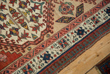 Detailed view of the vintage Serab rug's reciprocating pawn and meandering vine borders.
