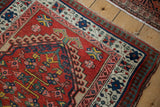 Worn corner of a vintage Serab rug showing the pawn motif border and tattered selvedge.