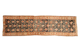 Antique Kurdish Hamadan runner, dusty navy abrashed ground with repeating rose motifs, terracotta border.