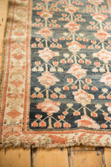 Antique Kurdish Hamadan rug's abrashed navy field, rose motifs, ivory border, and fringe.