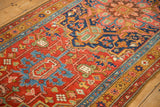 Detailed view of the gold ochre border and geometric palmettes on an antique Heriz runner rug.