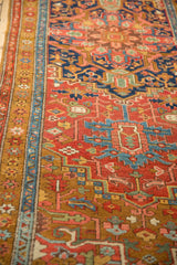 Even, low-pile weave of an antique Heriz rug's gold ochre border and red geometric field.