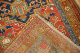 Folded corner of an antique Heriz rug showing its colorful pile and hand-knotted foundation.