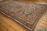 Angled view of an antique Soumac carpet highlighting its large-scale gul medallions and intricate borders.