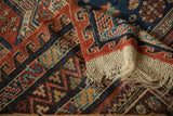 Original macrame fringe and serpent border detail on an antique handwoven Caucasus carpet.