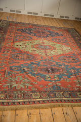 Corner of an antique Caucasus carpet showing intricate starburst motifs in red, jade, and blue.
