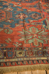 Angled view of the intricate geometric motifs and borders in an antique Soumac design carpet.