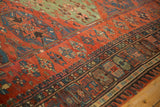 Intricate geometric borders and starburst motifs in red, jade green, and navy on a vintage Soumac carpet.